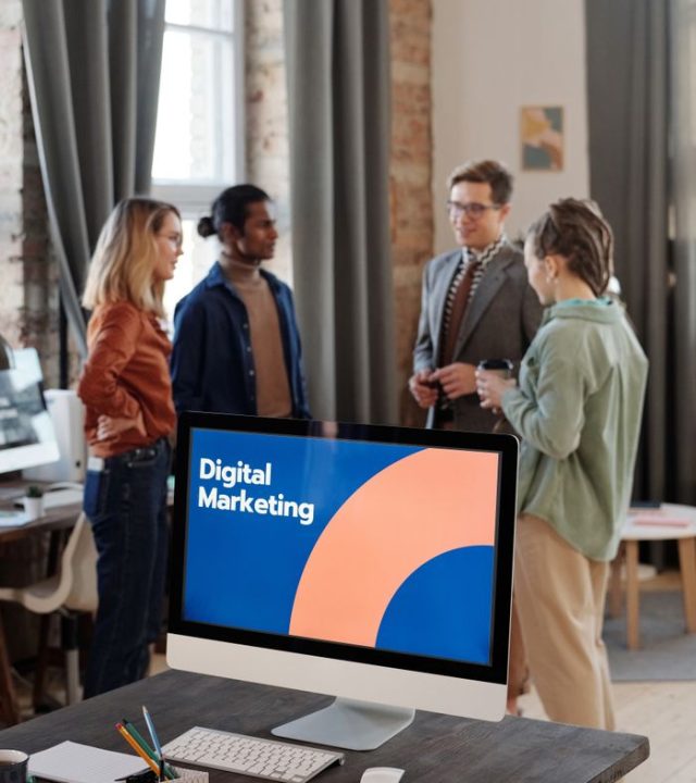 Business team engaged in a digital marketing discussion in a modern office setting.